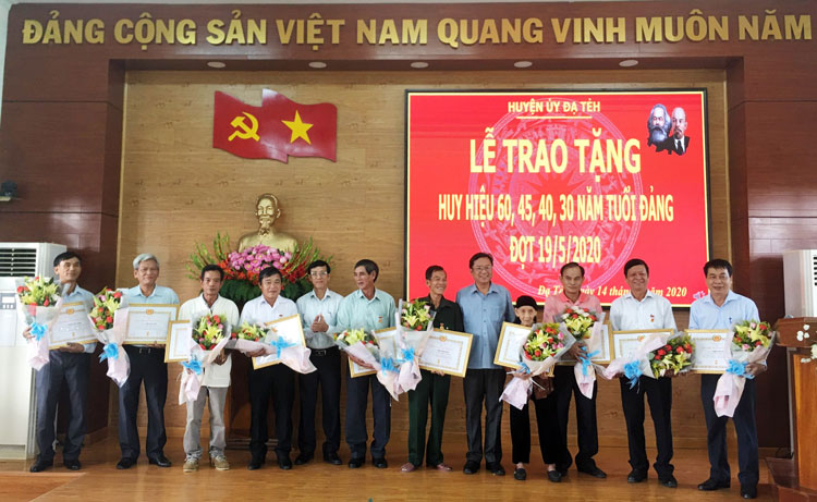 Đồng chí Tôn Thiện Đồng - Bí thư Huyện ủy Đạ Tẻh và đồng chí Nguyễn Mạnh Việt - Phó Bí thư Thường trực Huyện ủy Đạ Tẻh trao huy hiệu Đảng cho các đảng viên