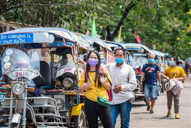 Người dân Lào đeo khẩu trang để phòng dịch COVID-19