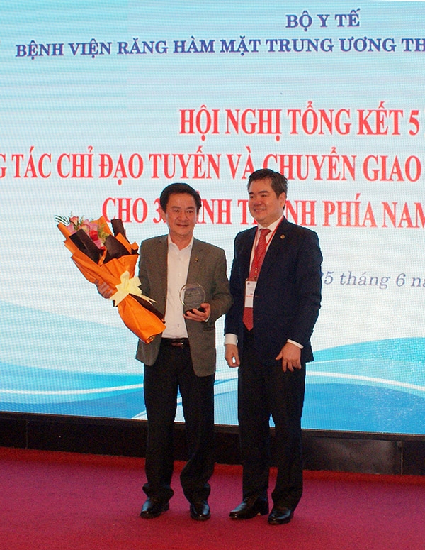 BSCKII Lê Trung Chánh - Giám đốc Bệnh viện Răng Hàm Mặt Trung ương TP Hồ Chí Minh tặng hoa và trao kỷ niệm chương cho ông Phan Văn Đa - Phó Chủ tịch UBND tỉnh Lâm Đồng
