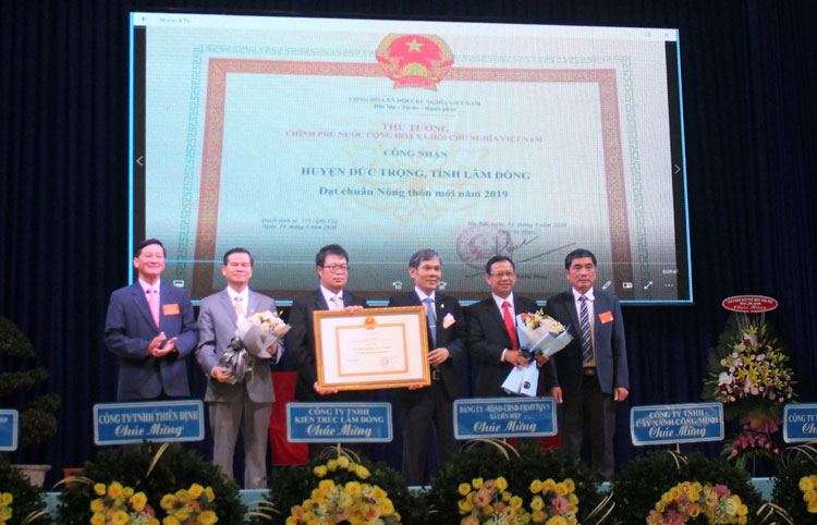 Đồng chí Trần Đức Quận - Phó Bí thư Thường trực Tỉnh ủy, Chủ tịch HĐND tỉnh và đồng chí Trần Văn Môn - Phó Cục trưởng, Phó Chánh Văn phòng điều phối NTM Trung ương trao Bằng công nhận đạt chuẩn NTM mới cho huyện Đức Trọng