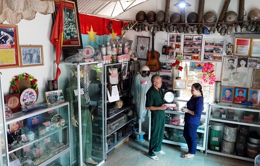 Thương binh 4/4 Bùi Văn Bình giới thiệu với khách tham quan về những kỷ vật mà ông đang lưu giữ. (Ảnh: Trung Kiên/TTXVN)