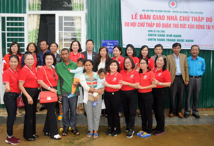 Các đại biểu và đoàn công tác từ thiện chụp hình lưu niệm trước căn nhà vừa bàn giao cho gia đình ông Lơ Mu Ha Klas