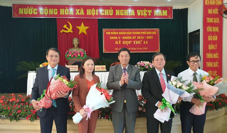 Ông Nghiêm Xuân Đức - Phó Bí thư Thành ủy Bảo Lộc, tặng hoa chúc mừng các đồng chí được bầu giữ các chức danh HĐND, UBND