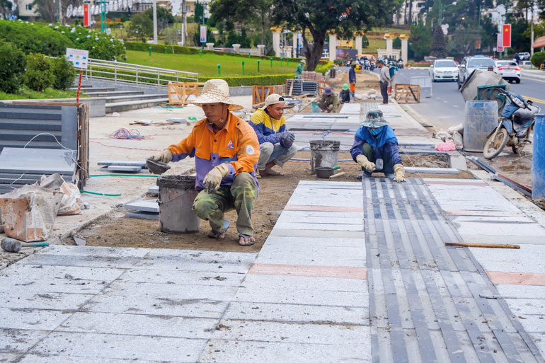 Công nhân đang lát đá vỉa hè quanh hồ Xuân Hương. Ảnh: Chính Thành