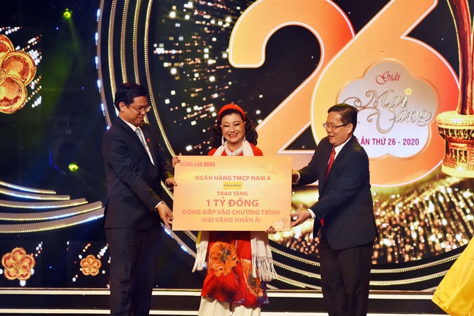 NSND Kim Cương - đại diện văn nghệ sĩ tiếp nhận bảng tượng trưng số tiền 1 tỉ đồng do ông Trần Ngọc Tâm - Tổng Giám đốc Ngân hàng TMCP Nam Á và ông Tô Đình Tuân, Tổng Biên tập Báo Người Lao Động, trao .Ảnh: NHÓM PHÓNG VIÊN