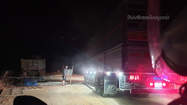 Dù đêm tối nhưng người đàn ông vẫn túc trực để mở rào chắn cho xe tải qua cầu Vĩnh Ninh