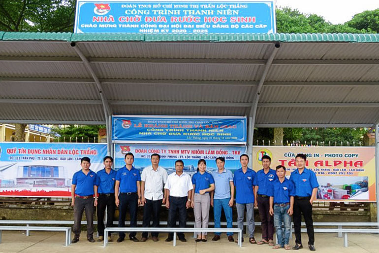 Anh Nguyễn Đức Nguyên (ngoài cùng bên trái) cùng các đoàn viên, thanh niên chụp hình lưu niệm trong công trình nhà chờ đưa rước học sinh