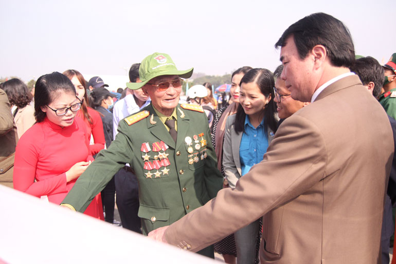 Các đại biểu trò chuyện với nhân vật trong một bức ảnh tại triển lãm