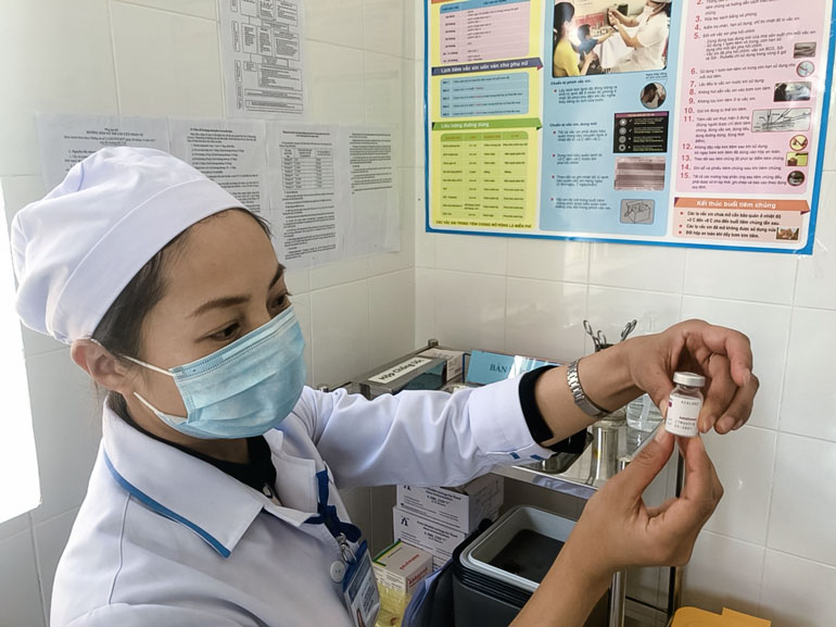 Cán bộ tiêm chủng kiểm tra vắc xin phòng Covid-19 của AstraZeneca sản xuất trước khi tiêm