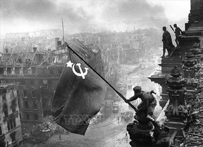 Chiến sĩ Hồng quân thuộc Phương diện quân Byelorussia 1 cắm lá cờ chiến thắng lên nóc Nhà Quốc hội Đức, chiều 30/4/1945. Ảnh: Tư liệu quốc tế