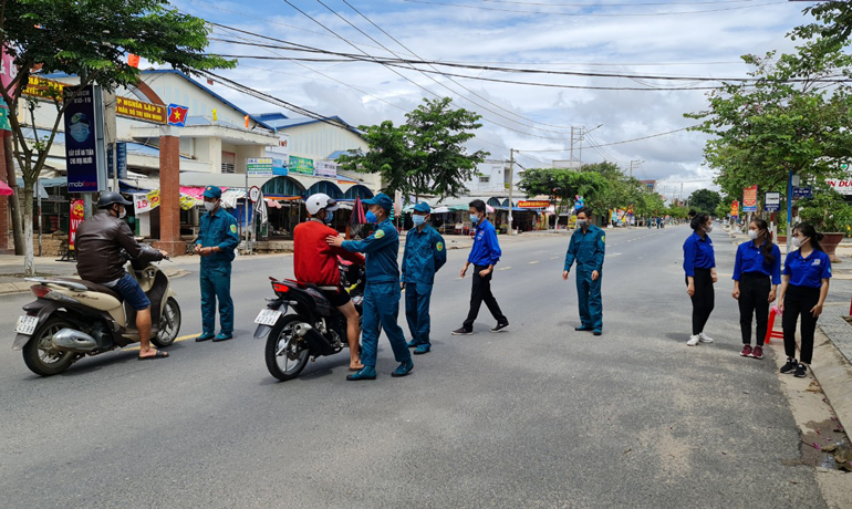 Dân quân cơ động và thanh niên tình nguyện thị trấn Thạnh Mỹ tuyên truyền hướng dẫn người dân trong khu phong tỏa phòng chống Covid-19