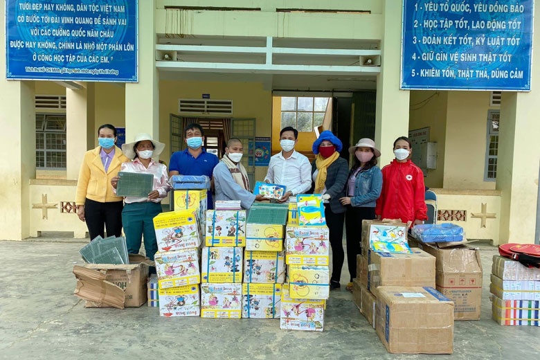 Đại diện nhóm Thiện nguyện Fi Nôm trao vở, viết cho các em học sinh thông qua thầy hiệu trưởng trường Chơ Ré (Đa Quyn)