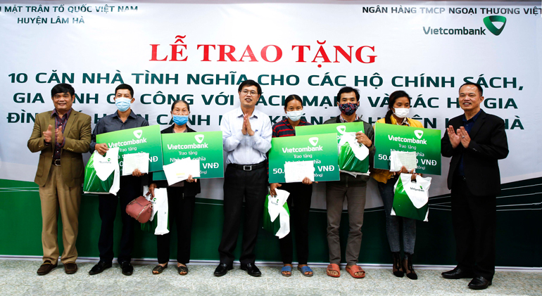 Phó Bí thư Thường trực Huyện ủy Lâm Hà Hà Văn Thuận (bìa trái), Chủ tịch UBND huyện Lâm Hà Hoàng Sỹ Bích (giữa) và Giám đốc Ngân hàng Nhà nước chi nhánh tỉnh Lâm Đồng Trương Quốc Thụ (bìa phải) trao biểu trưng tài trợ nhà và quà cho 5 gia đình