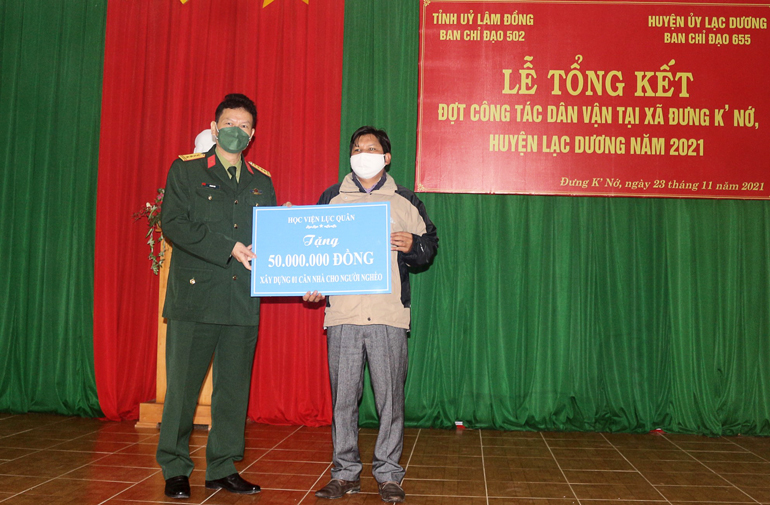 Đại diện lãnh đạo Học viện Lục quân trao bảng tượng trưn Nhà Đại đoàn kết cho người dân