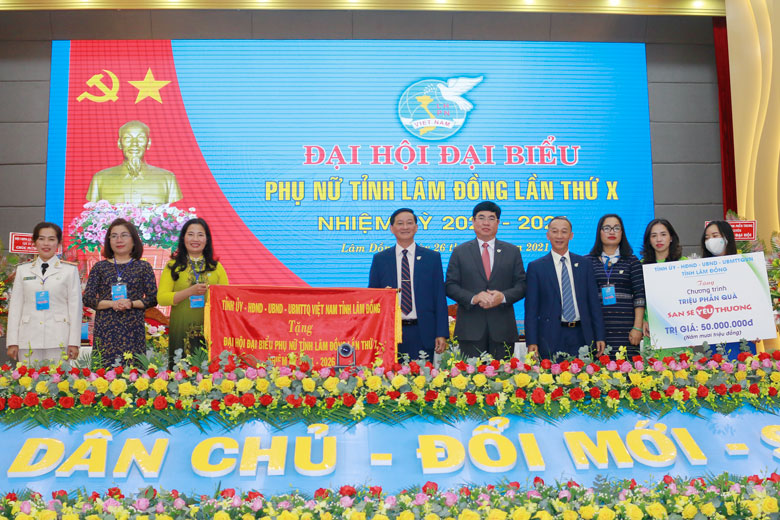 Các đồng chí lãnh đạo Tỉnh ủy trao tặng Đại hội bức trướng với nội dung “Đoàn kết - Sáng tạo - Hội nhập - Đổi mới - Phát triển” và ủng hộ 50 triệu đồng hưởng ứng Chương trình “Triệu phần quà san sẻ yêu thương” do Hội LHPN tỉnh phát động. Ảnh: T.Hương