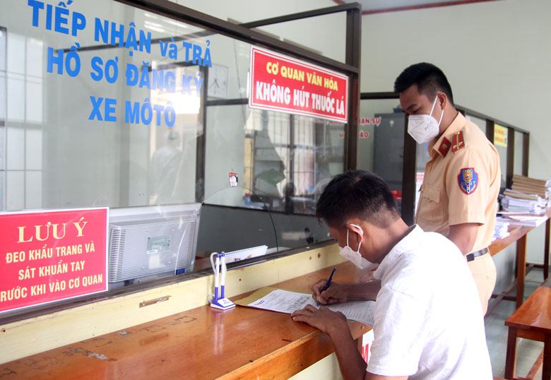 Cán bộ công an hướng dẫn người dân làm thủ tục đăng ký xe