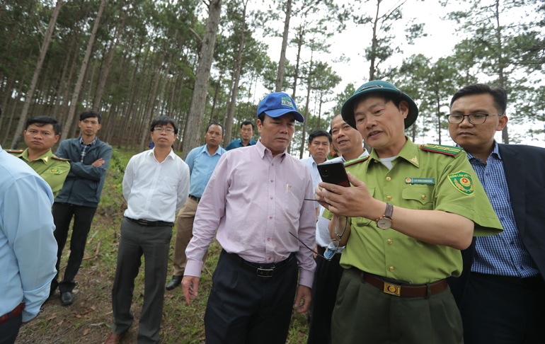 Lãnh đạo Hạt Kiểm lâm huyện Lạc Dương trao đổi với ông Phạm S các vị trí đất rừng bị lấn chiếm qua bản đồ trên điện thoại