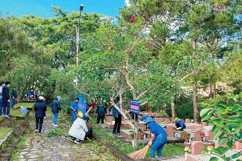 Tuổi trẻ Đoàn Khối Doanh nghiệp dọn dẹp nghĩa trang liệt sĩ. Ảnh: Bình An