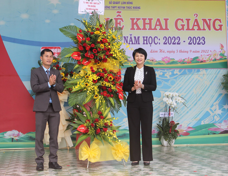Đồng chí Phạm Thị Phúc - Ủy viên Ban Thường vụ Trưởng Ban Dân vận Tỉnh ủy tỉnh tặng hoa chúc chúc mừng thầy và trò Trường THPT Huỳnh Thúc Kháng