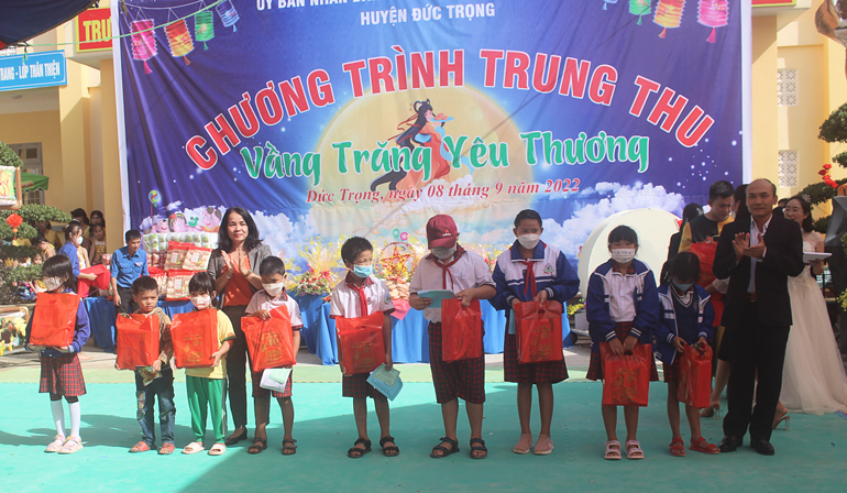 Bà Phạm Thị Thanh Thúy - Phó Chủ tịch UBND huyện và ông Võ Khắc Chương – Phó Trưởng phòng Lao động Thương binh và Xã hội, trao quà cho các em học sinh có hoàn cảnh khó khăn